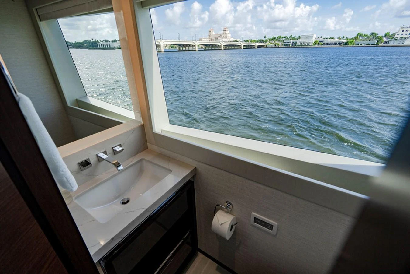 A serene view from the yacht's bathroom, featuring a sleek sink and large window overlooking the water. aboard M/Y 12 Yacht for Sale