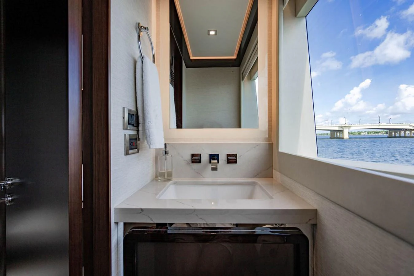 A sleek and modern bathroom with a view of the water through a large window. aboard M/Y 12 Yacht for Sale