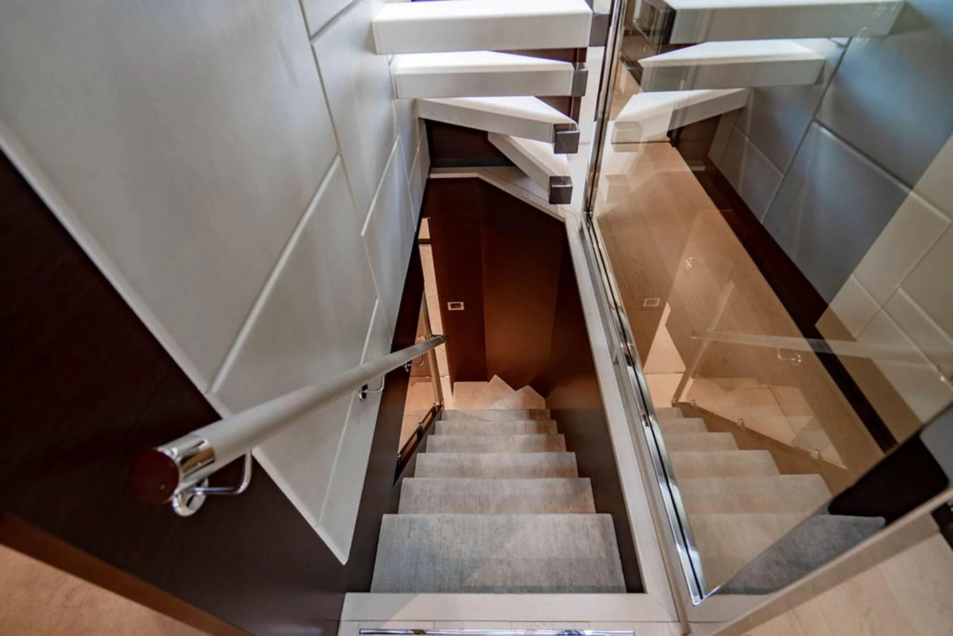 A sleek and modern staircase with a mirrored wall and stylish handrail. aboard M/Y 12 Yacht for Sale