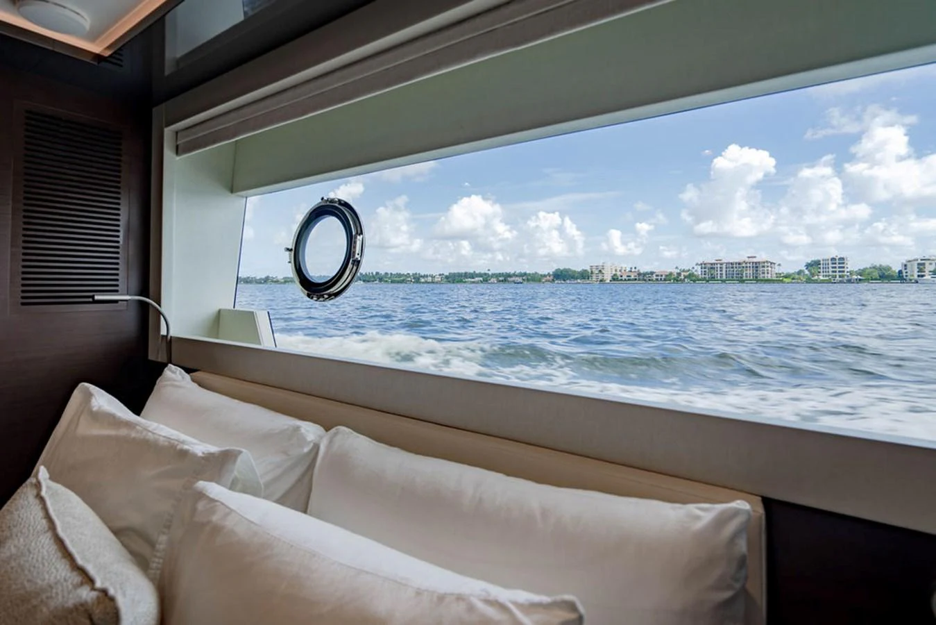 A serene view of the sea from a cozy cabin with plush pillows and a large window. aboard M/Y 12 Yacht for Sale