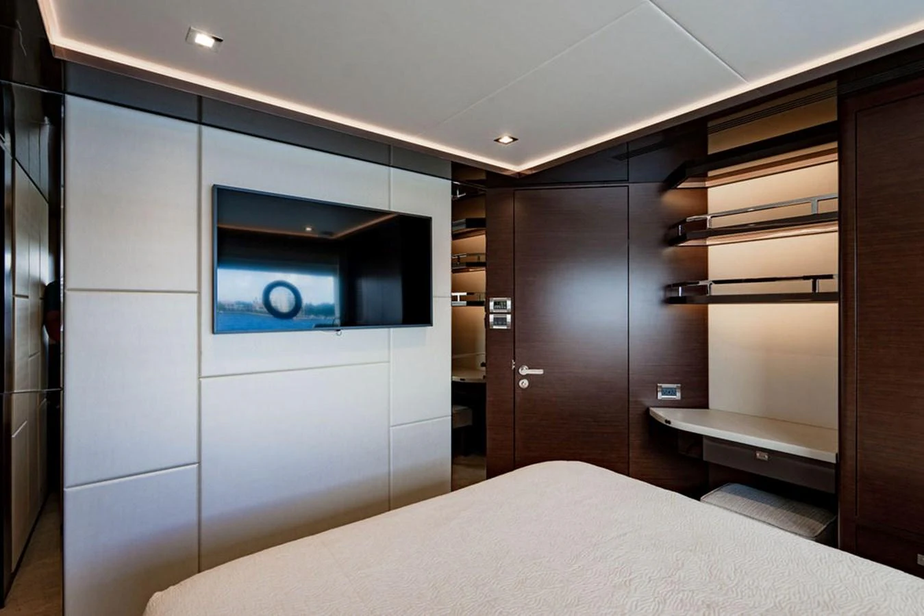 The stateroom features modern decor with a wall-mounted TV and ample storage space. aboard M/Y 12 Yacht for Sale