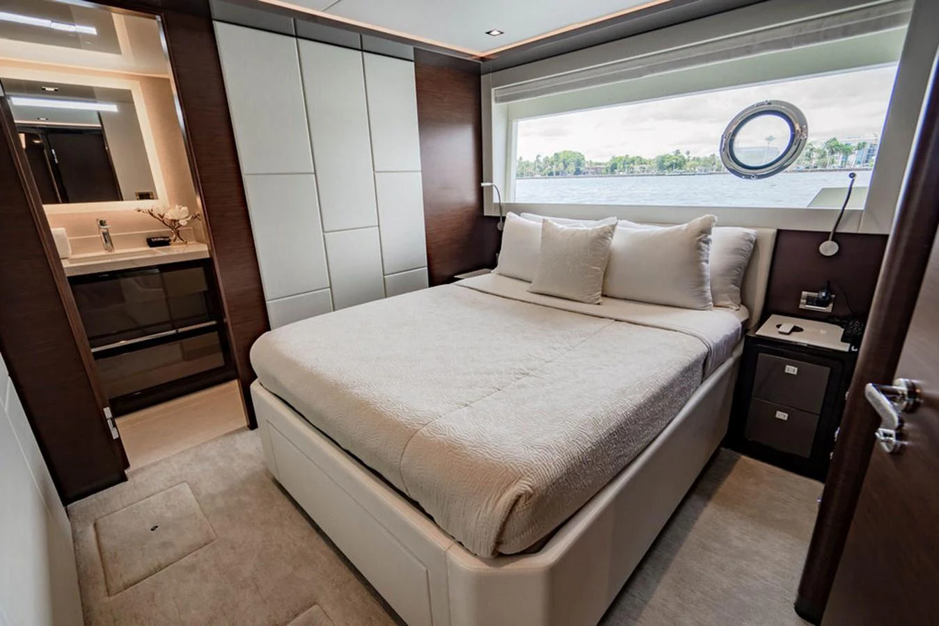 The stateroom features a plush bed with elegant linens and a large window offering scenic views. aboard M/Y 12 Yacht for Sale