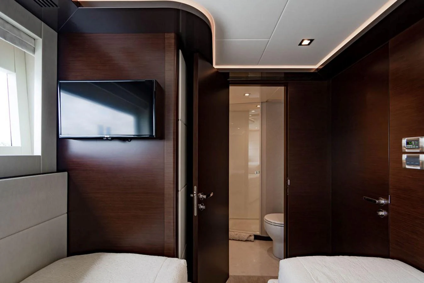 The image showcases a modern yacht interior with a sleek, dark wood finish and a minimalist design. aboard M/Y 12 Yacht for Sale