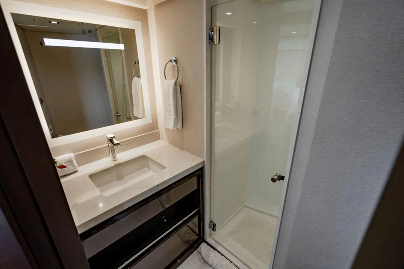 The yacht's bathroom features a modern sink, a large mirror, and a glass-enclosed shower. aboard M/Y 12 Yacht for Sale