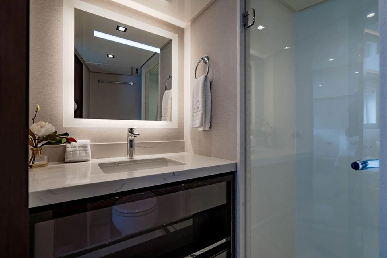 The yacht's bathroom features a modern sink with a backlit mirror and elegant fixtures. aboard M/Y 12 Yacht for Sale