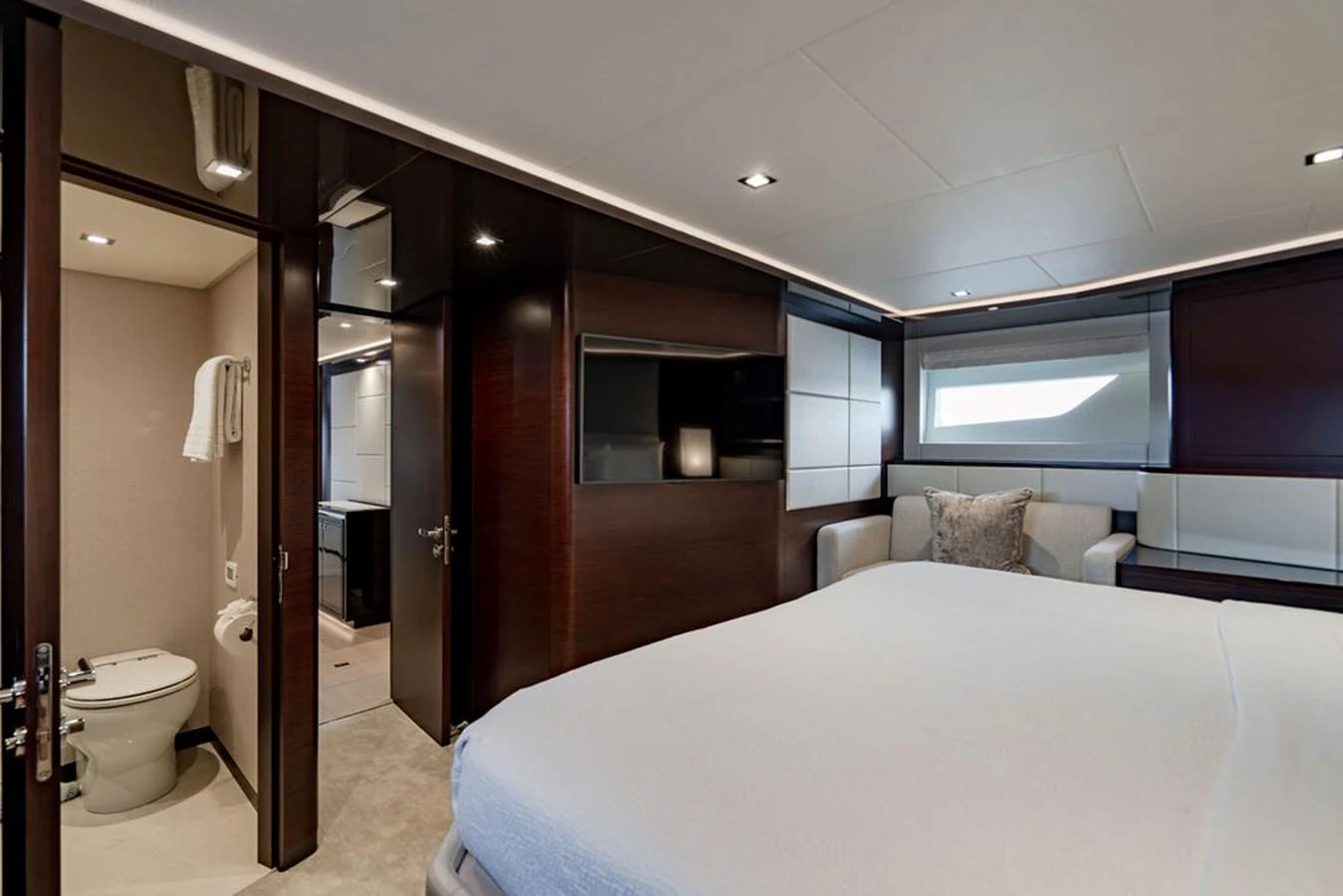 The master stateroom features a spacious bed, a seating area, and an en-suite bathroom. aboard M/Y 12 Yacht for Sale