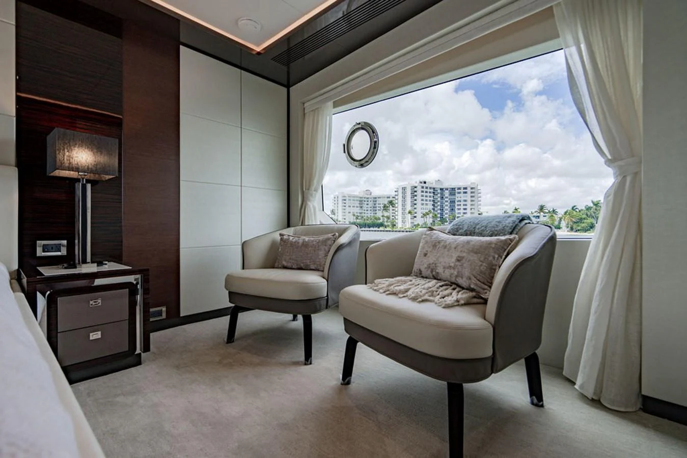 This elegant stateroom features plush seating and a large window with a scenic view. aboard M/Y 12 Yacht for Sale
