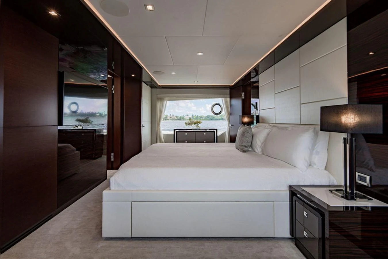 The master stateroom features a luxurious bed with elegant furnishings and a scenic view through the window. aboard M/Y 12 Yacht for Sale