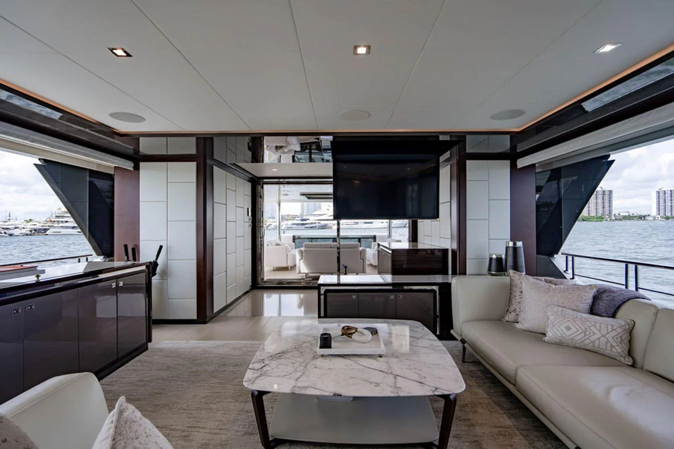 The yacht's salon features a luxurious seating area with a marble coffee table and large windows offering stunning views. aboard M/Y 12 Yacht for Sale