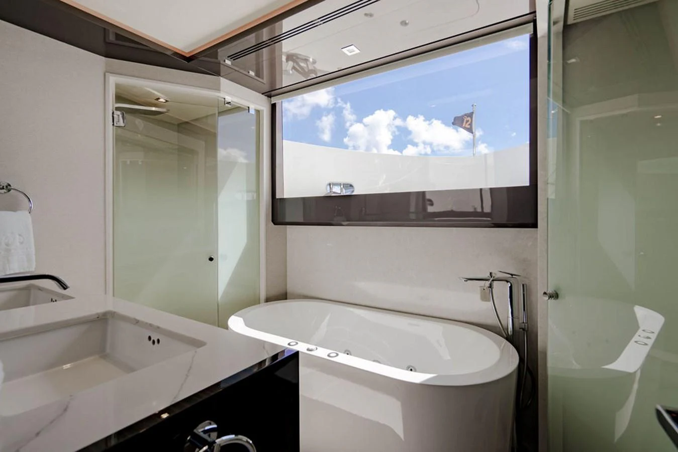 A luxurious bathroom with a large bathtub and modern fixtures, offering a serene view through a window. aboard M/Y 12 Yacht for Sale