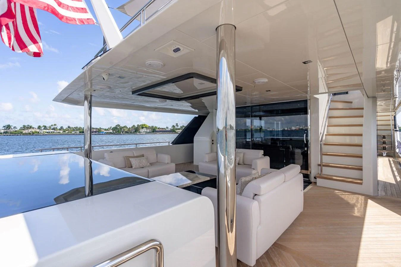 The aft deck offers a luxurious outdoor seating area with plush white sofas and a polished finish. aboard M/Y 12 Yacht for Sale