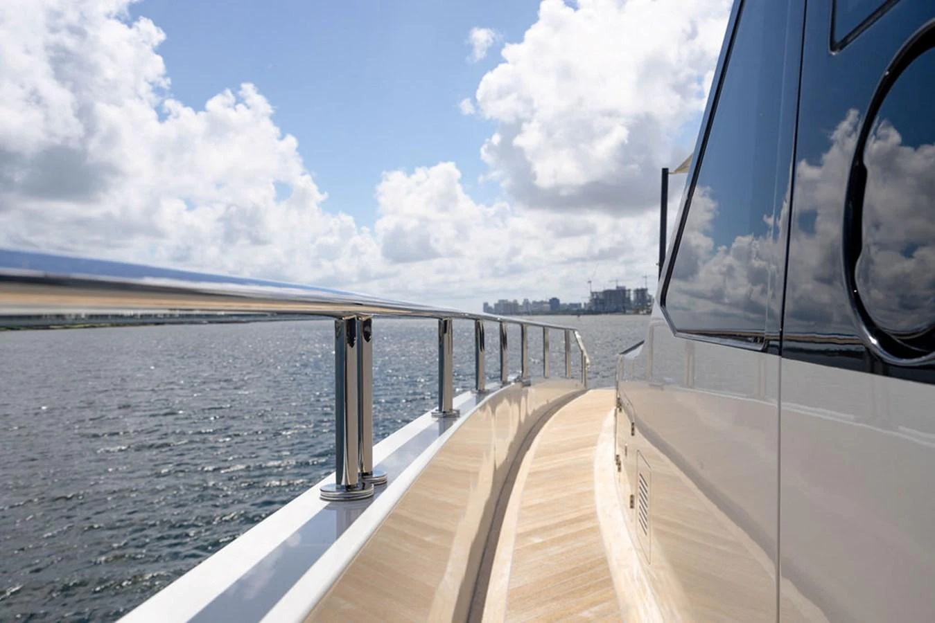 The sleek side deck of the yacht offers a stunning view of the open water and distant skyline. aboard M/Y 12 Yacht for Sale