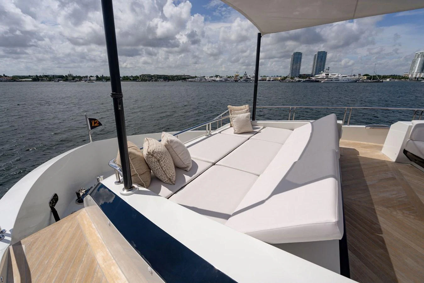 The sundeck offers a spacious lounging area with plush cushions and a scenic view of the water. aboard M/Y 12 Yacht for Sale