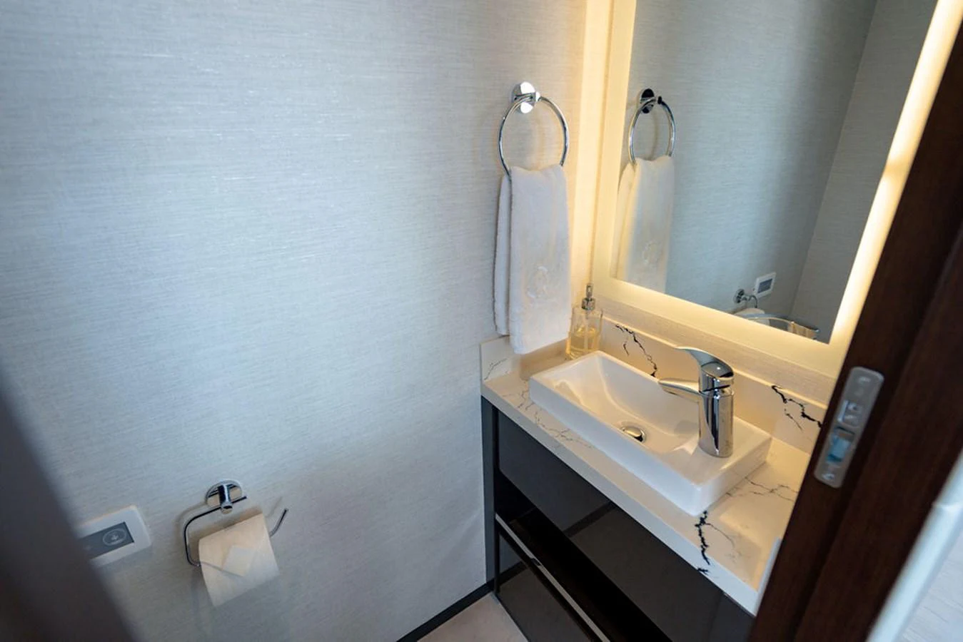 A sleek and modern bathroom with a marble countertop and illuminated mirror. aboard M/Y 12 Yacht for Sale