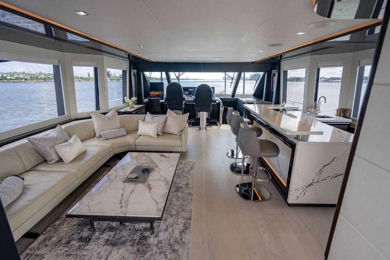 The salon features a luxurious seating area with a modern design and panoramic windows offering stunning views. aboard M/Y 12 Yacht for Sale