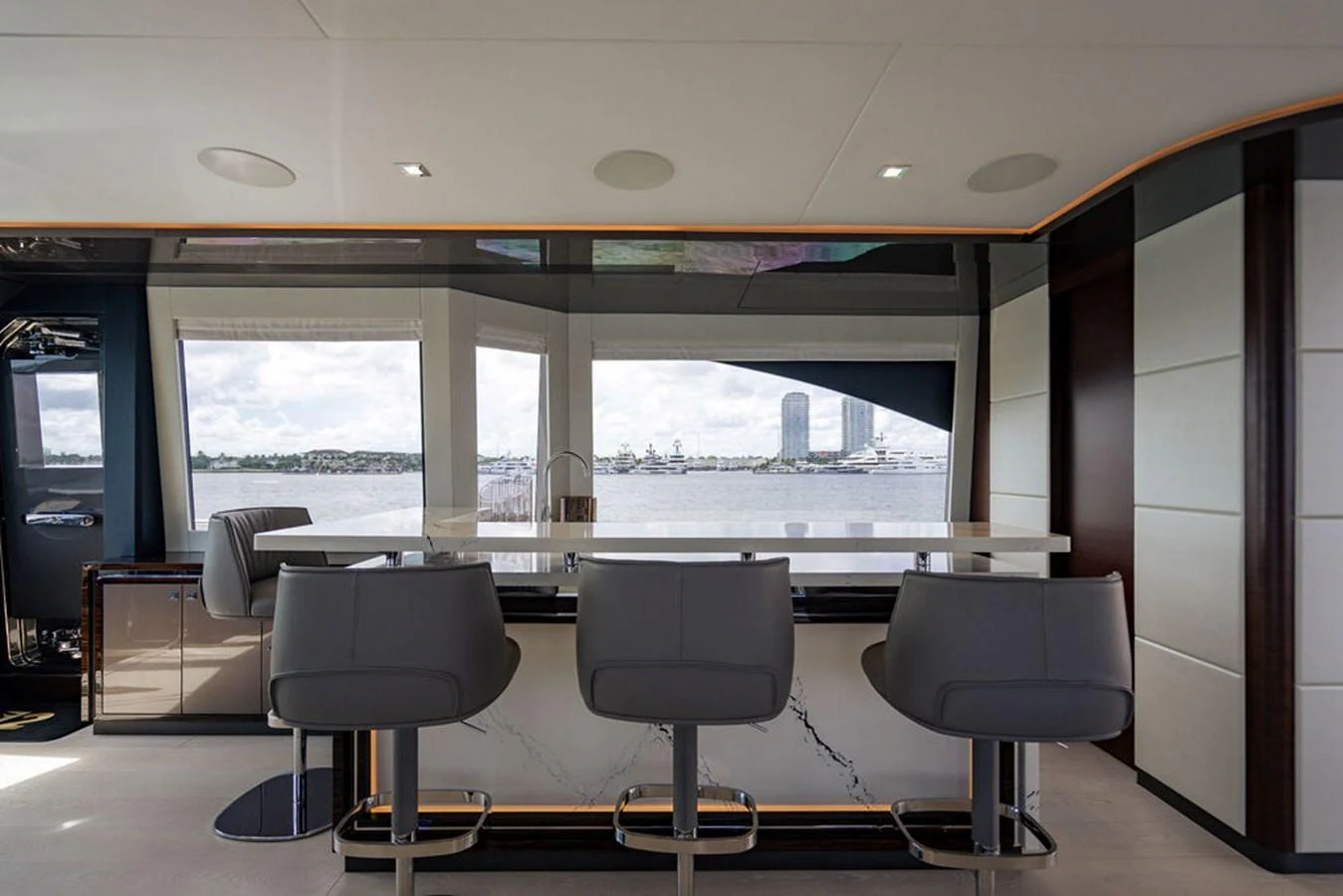 The modern galley features a sleek bar area with stylish seating and panoramic windows offering stunning views. aboard M/Y 12 Yacht for Sale