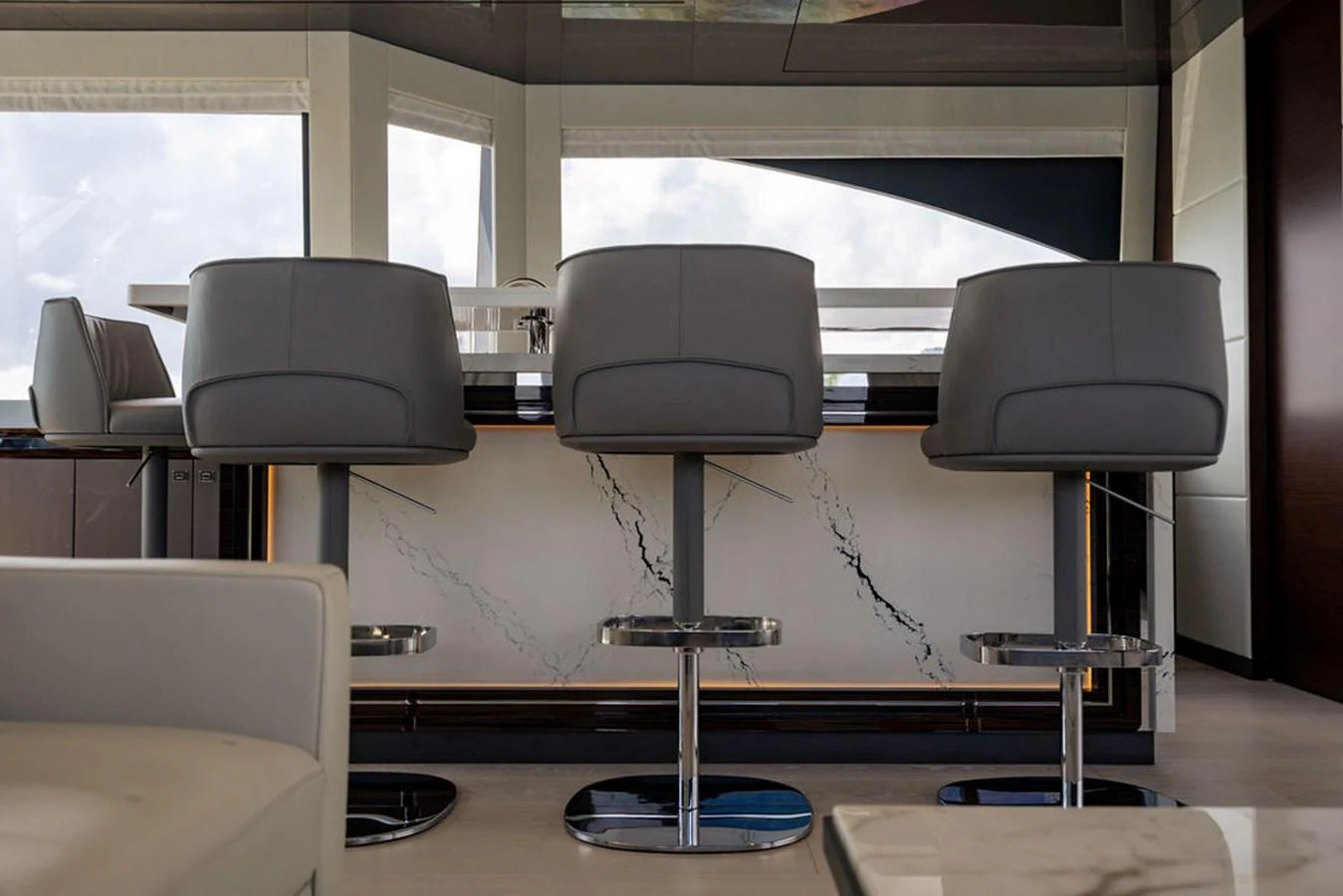 The yacht's interior features a sleek, modern bar area with stylish seating. aboard M/Y 12 Yacht for Sale