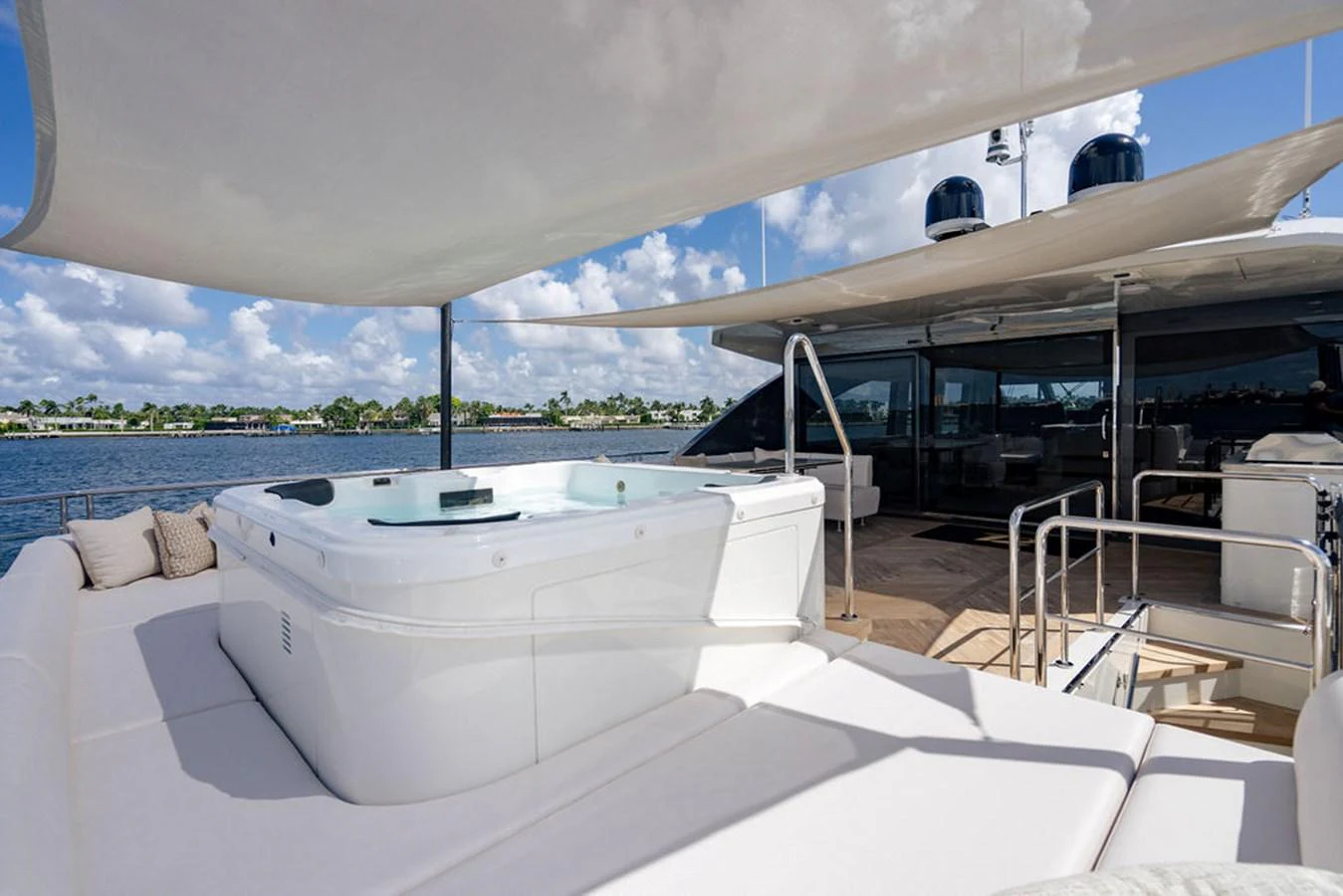 The sundeck features a luxurious hot tub surrounded by comfortable lounging areas under a shade canopy. aboard M/Y 12 Yacht for Sale