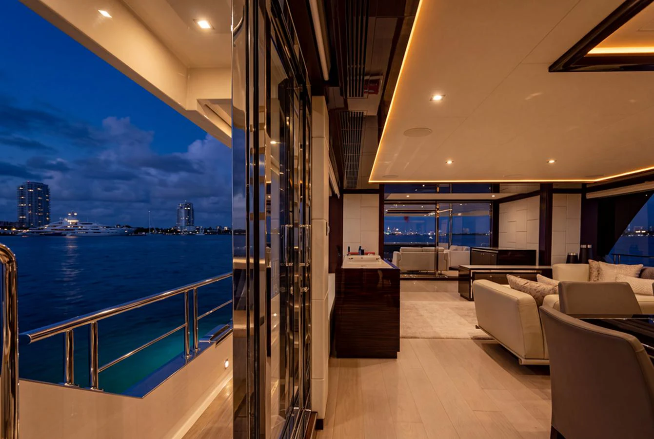 The yacht's salon offers a luxurious and spacious area with elegant furnishings and a stunning view of the water at dusk. aboard M/Y 12 Yacht for Sale