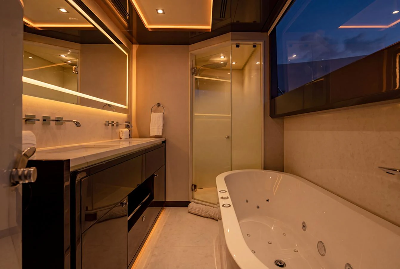 The yacht's bathroom features a luxurious bathtub and modern fixtures, illuminated by warm ambient lighting. aboard M/Y 12 Yacht for Sale