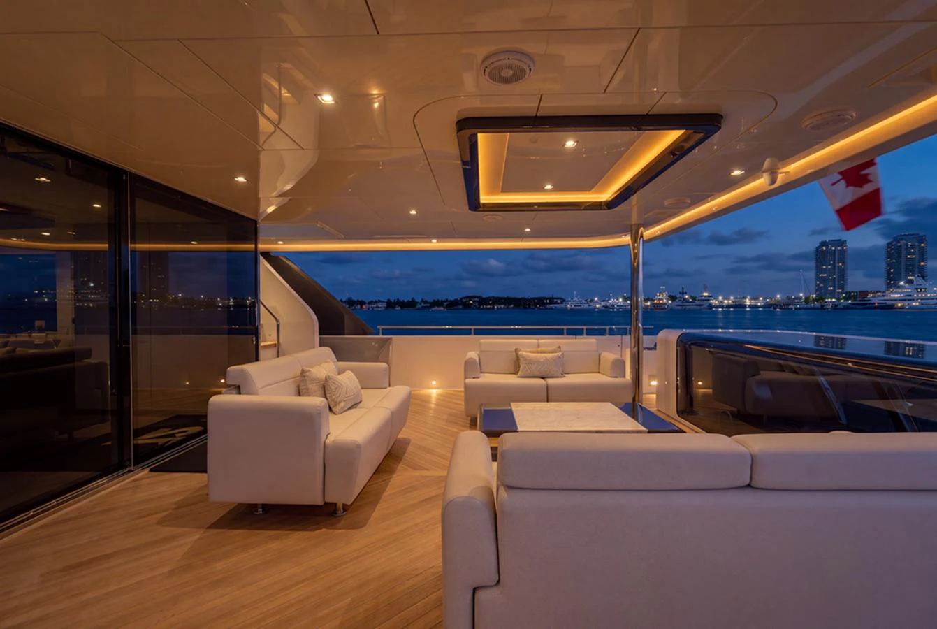 The aft deck features elegant seating with a stunning evening view of the cityscape. aboard M/Y 12 Yacht for Sale