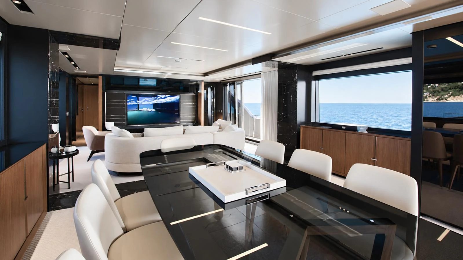 The yacht's salon features a luxurious seating area with a large TV and panoramic ocean views. aboard GIO4 Yacht for Sale