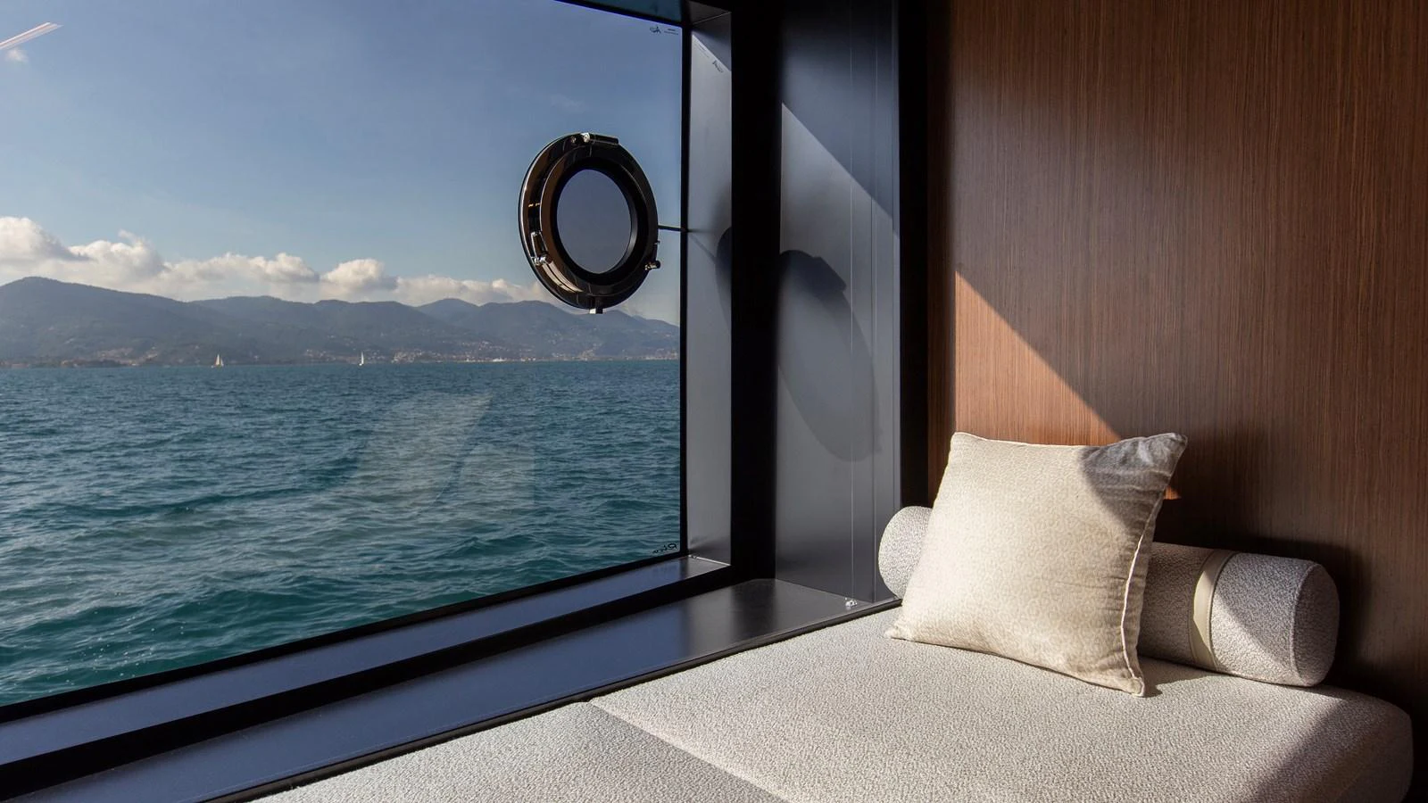 A serene interior space with a large window offering a stunning view of the sea and mountains. aboard GIO4 Yacht for Sale