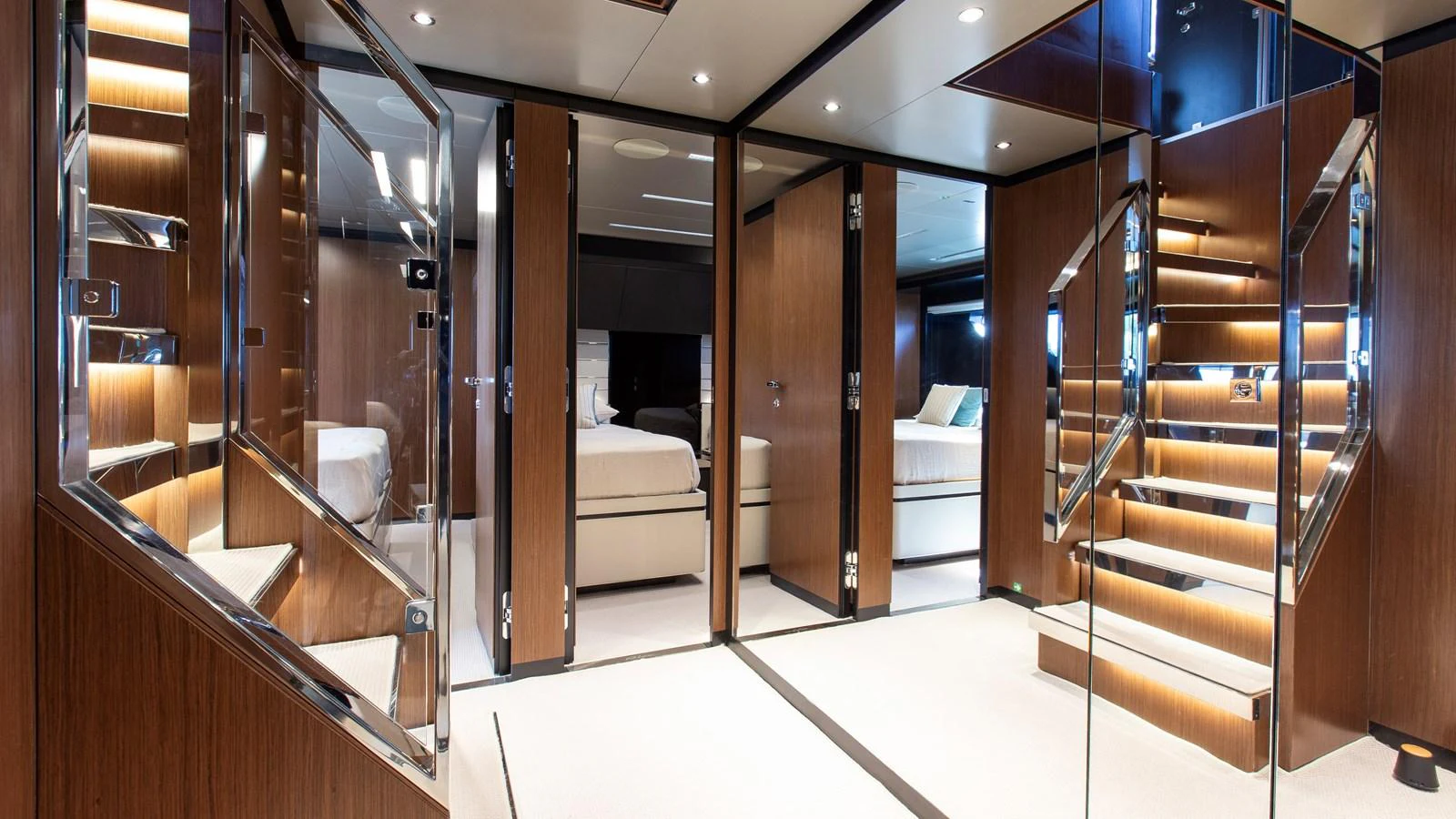 The yacht's interior features a sleek and modern staircase with warm wooden accents and ambient lighting. aboard GIO4 Yacht for Sale