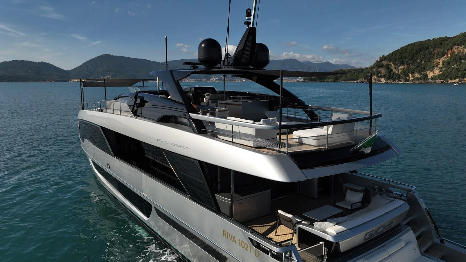 A sleek and modern yacht cruising in serene blue waters with a mountainous backdrop. aboard GIO4 Yacht for Sale