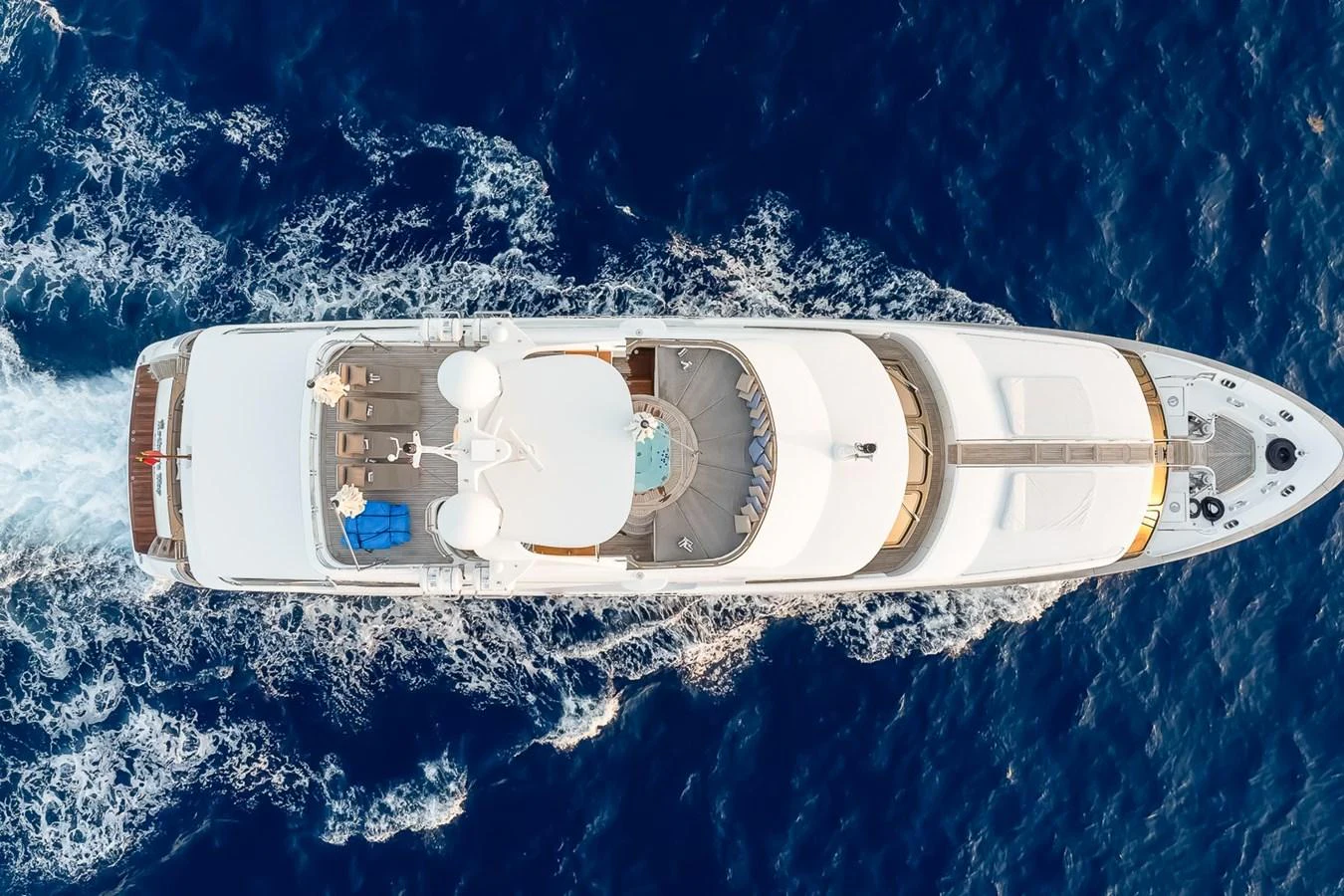 A stunning aerial view of a luxurious yacht cruising through deep blue waters. aboard GOTTA GO Yacht for Sale