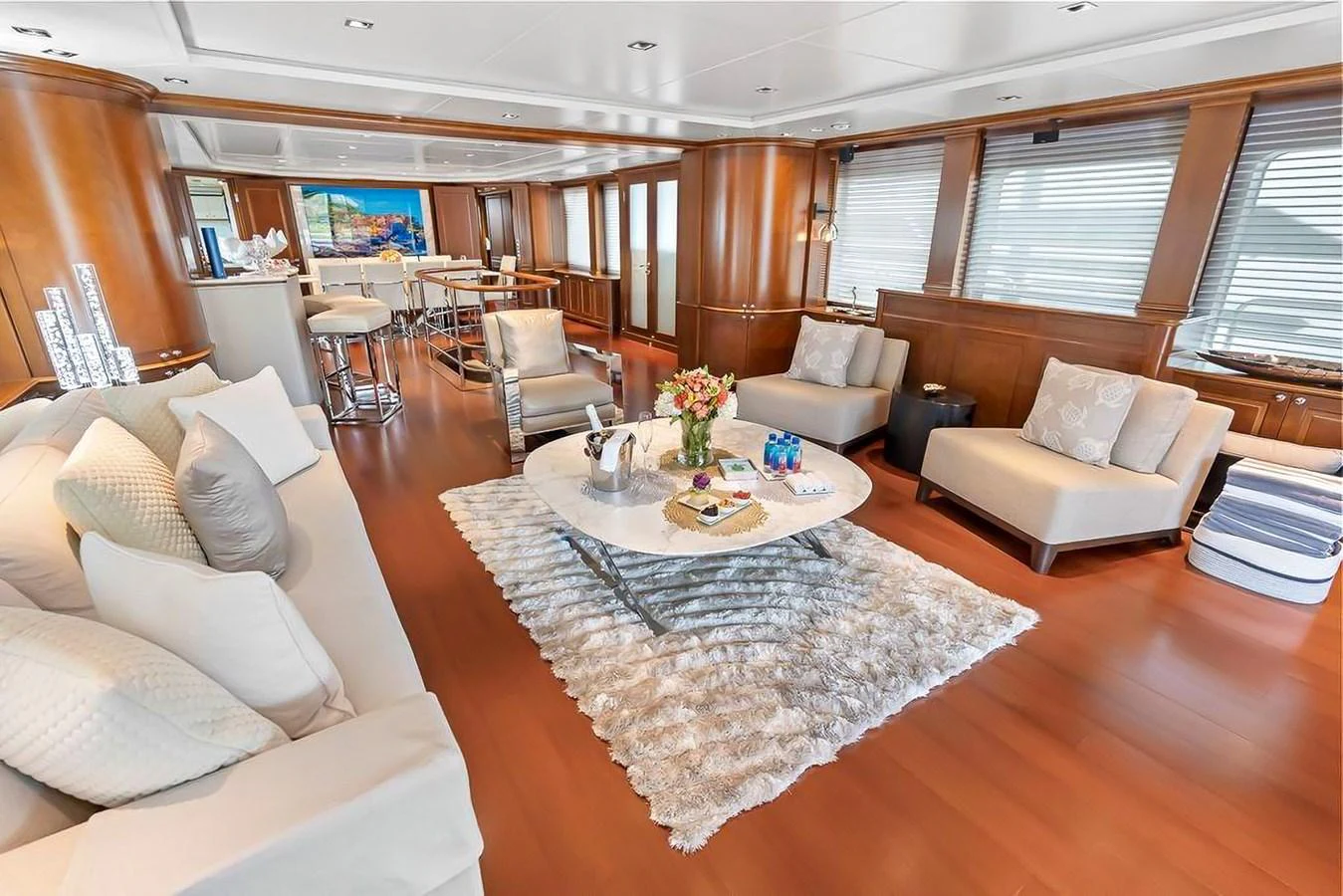 The yacht's salon features elegant seating, a plush rug, and ample natural light. aboard GOTTA GO Yacht for Sale