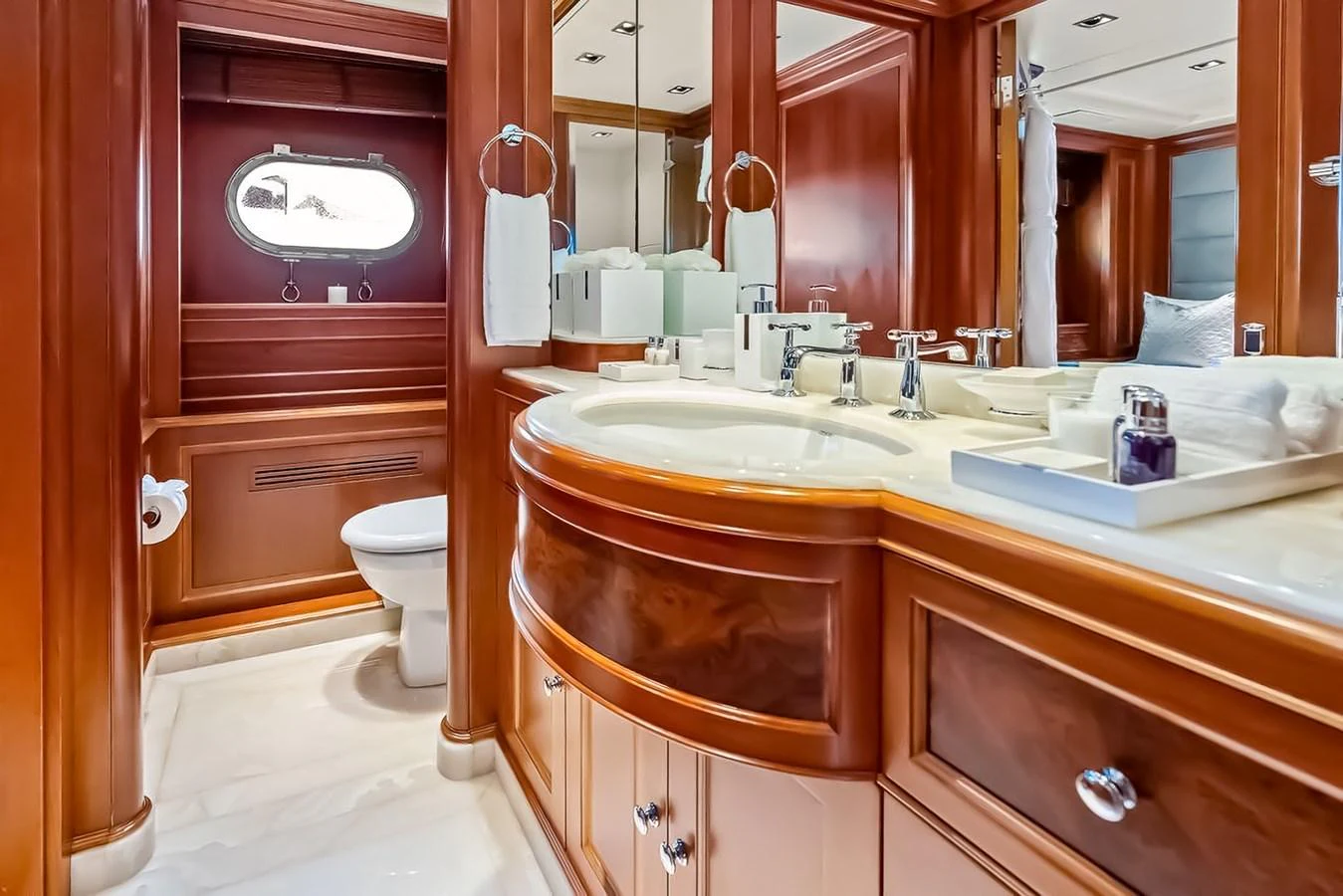 The yacht's bathroom features elegant wood paneling and a well-appointed vanity area. aboard GOTTA GO Yacht for Sale