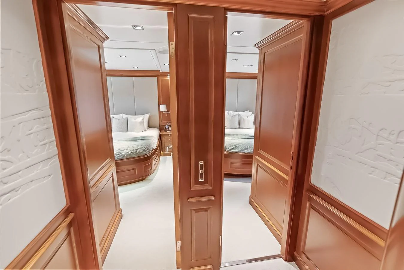 The image showcases a luxurious stateroom with elegant wood paneling and plush bedding. aboard GOTTA GO Yacht for Sale