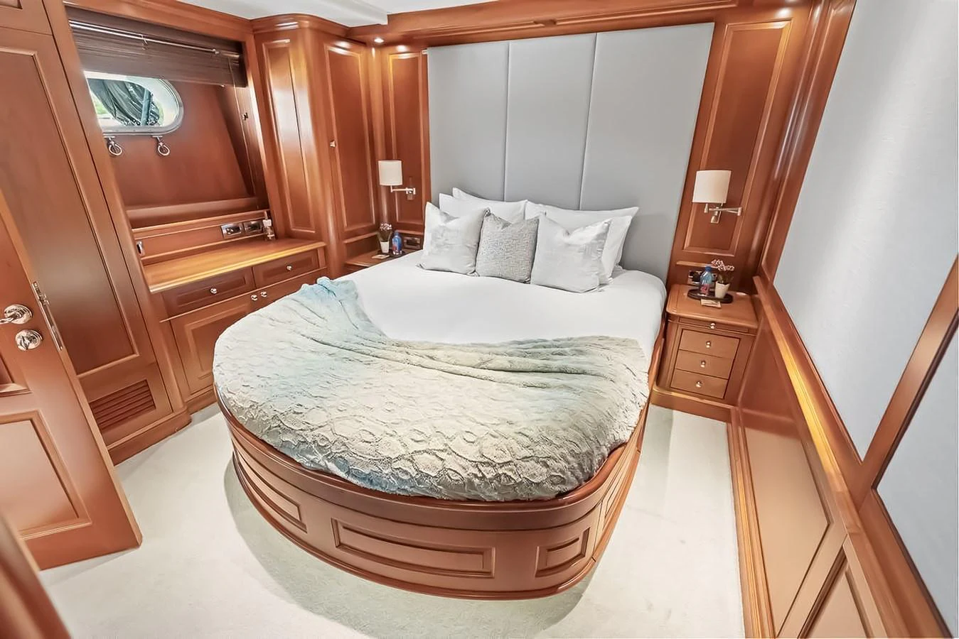 The stateroom features a cozy bed with elegant wooden cabinetry and soft lighting. aboard GOTTA GO Yacht for Sale