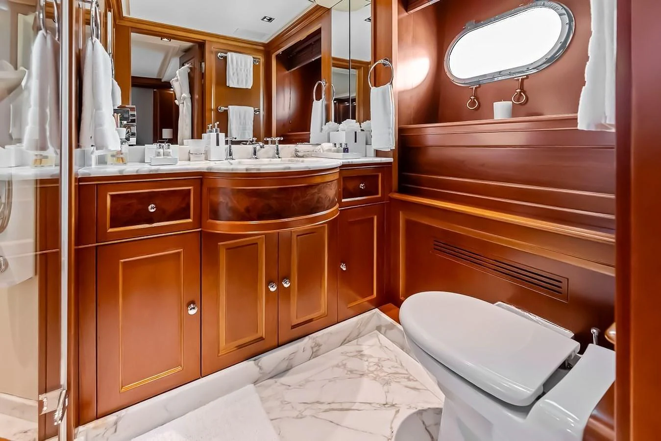 The yacht's bathroom features elegant wood cabinetry and a marble floor, creating a luxurious and refined atmosphere. aboard GOTTA GO Yacht for Sale