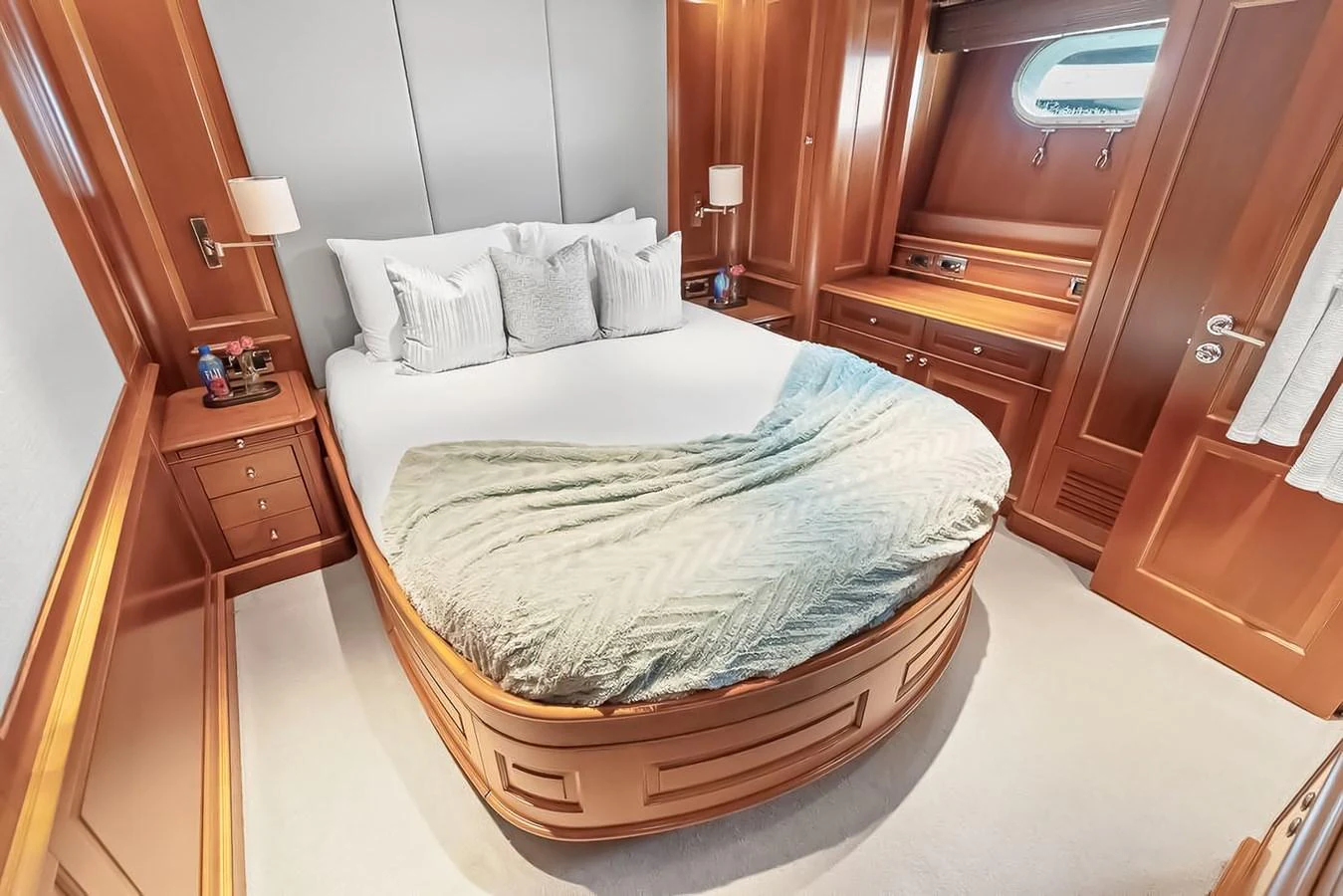 A cozy stateroom featuring a plush bed with elegant wood paneling and soft lighting. aboard GOTTA GO Yacht for Sale