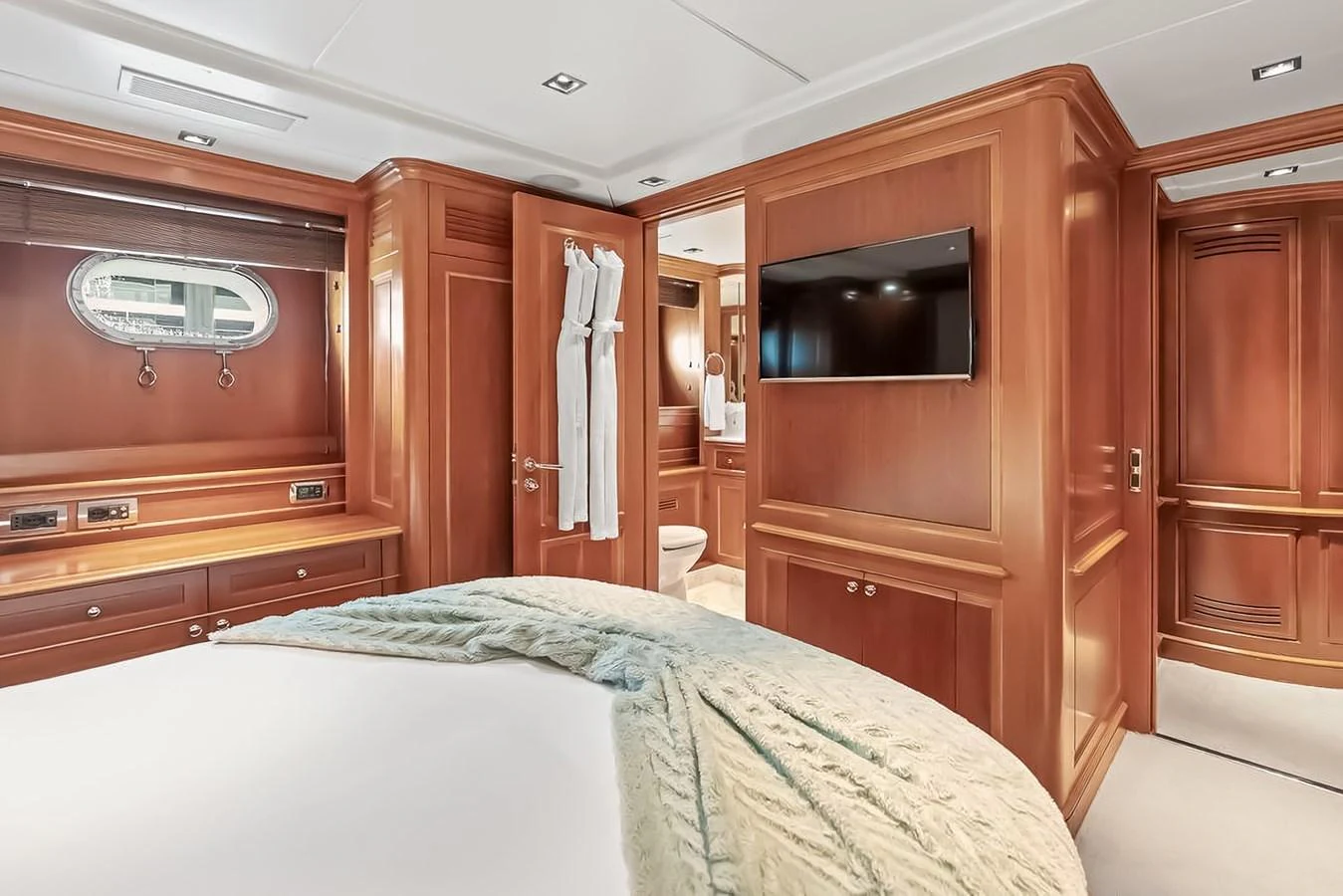 The stateroom features luxurious wood paneling, a plush bed, and modern amenities for ultimate comfort. aboard GOTTA GO Yacht for Sale