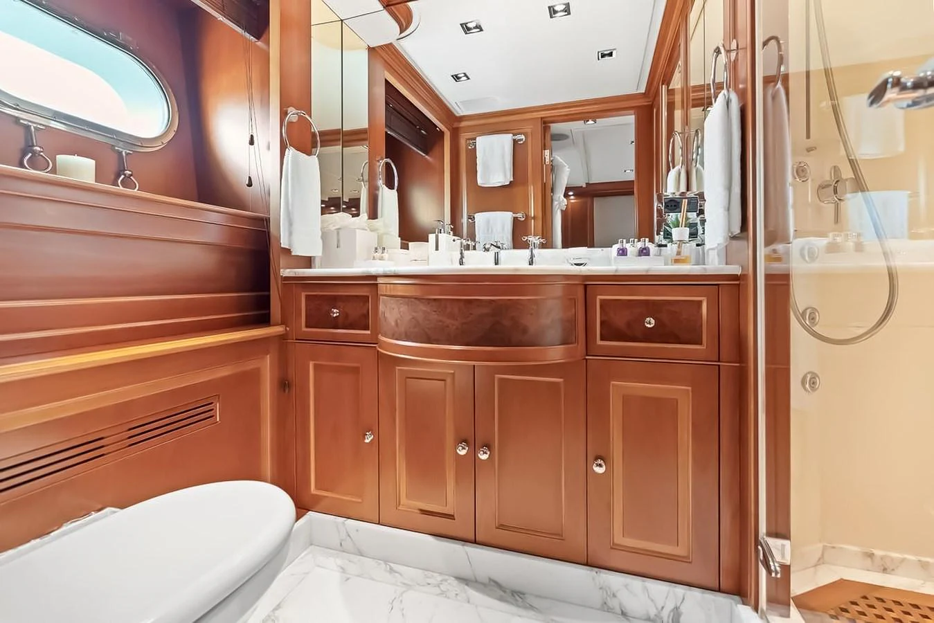 The yacht's bathroom features elegant wood cabinetry and a marble floor, creating a luxurious and serene atmosphere. aboard GOTTA GO Yacht for Sale