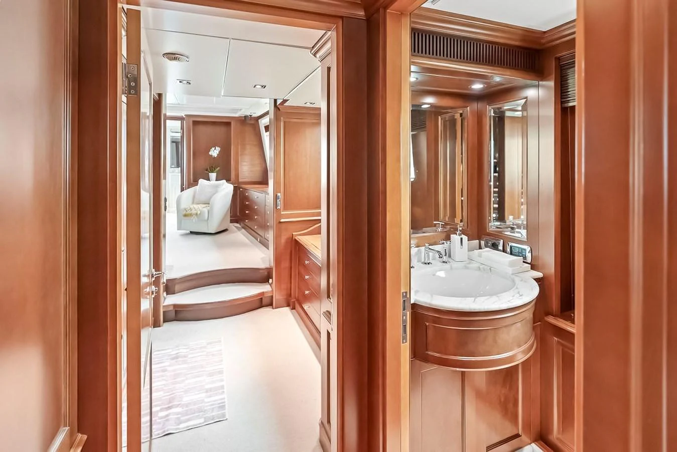The yacht's interior features a luxurious hallway leading to a cozy seating area and a well-appointed bathroom. aboard GOTTA GO Yacht for Sale