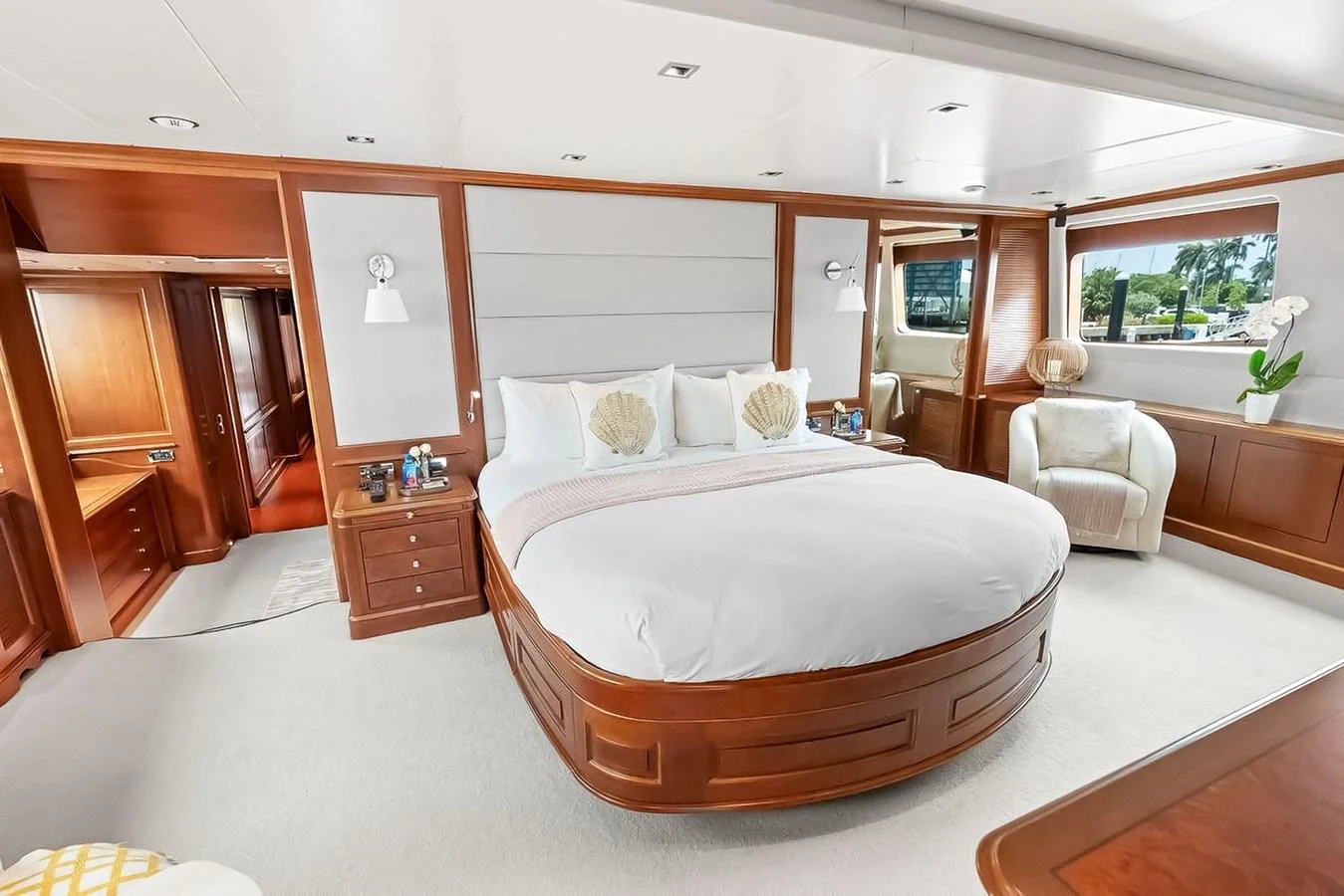 The master stateroom features a spacious bed with elegant wooden accents and ample natural light. aboard GOTTA GO Yacht for Sale