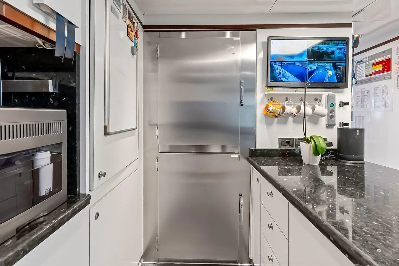 The galley features modern stainless steel appliances and sleek black countertops, providing a functional and stylish space for meal preparation. aboard GOTTA GO Yacht for Sale