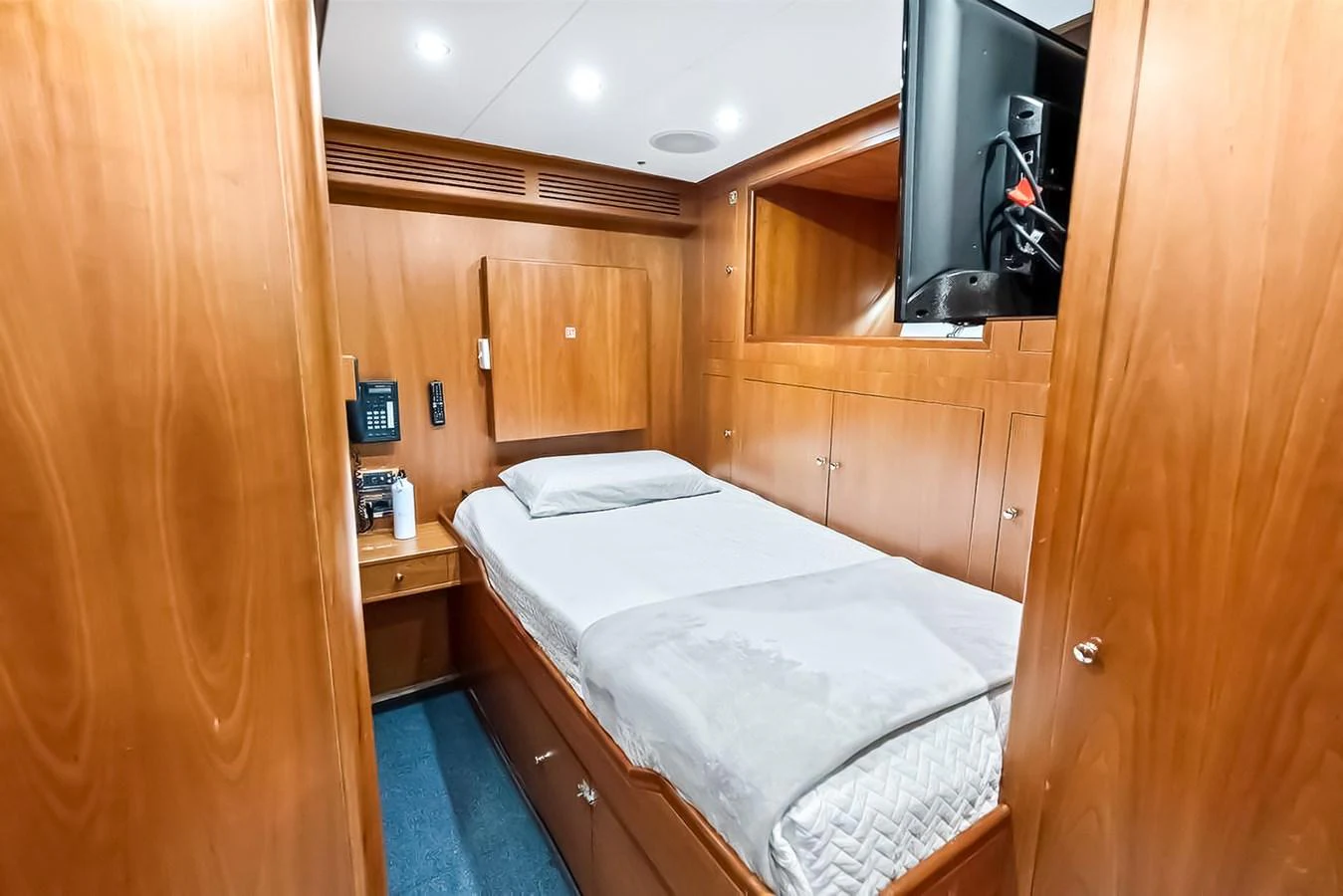 A cozy cabin with a comfortable bed and wooden furnishings. aboard GOTTA GO Yacht for Sale