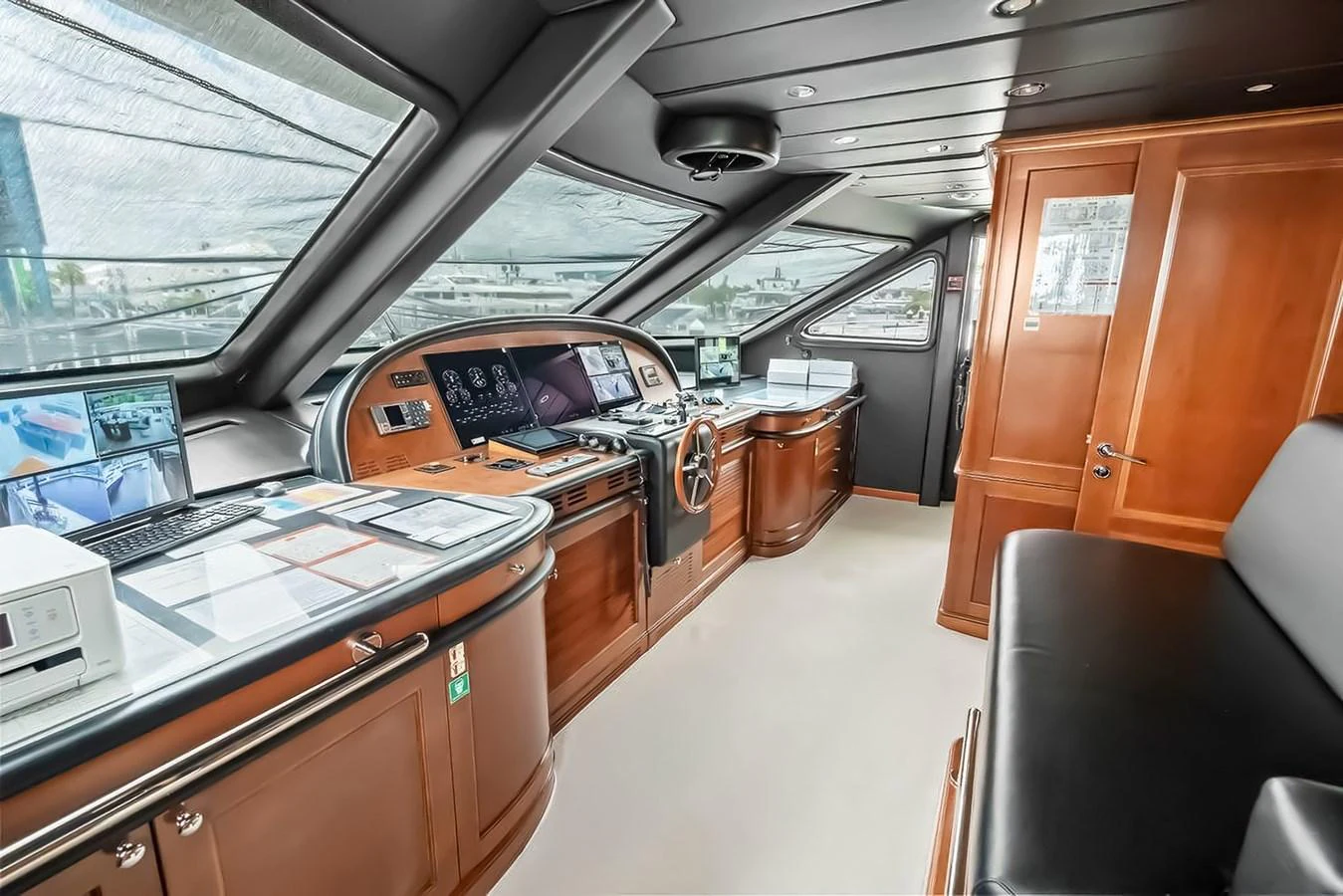 The helm station features advanced navigation equipment and luxurious wood finishes. aboard GOTTA GO Yacht for Sale