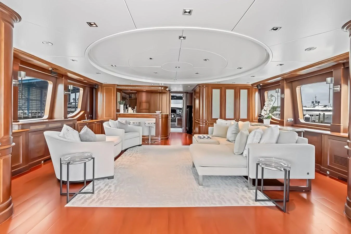 The salon features elegant wood paneling, plush seating, and ample natural light. aboard GOTTA GO Yacht for Sale
