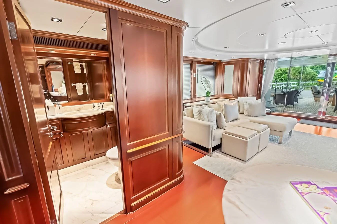 The yacht's interior features a cozy living area with plush seating and a view of the outdoor deck. aboard GOTTA GO Yacht for Sale