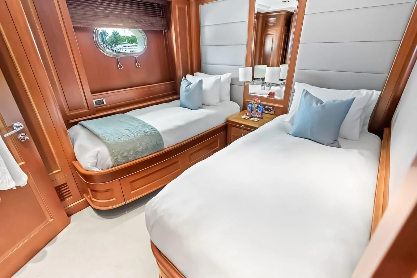 The guest stateroom features two twin beds with plush bedding and elegant wood finishes. aboard GOTTA GO Yacht for Sale