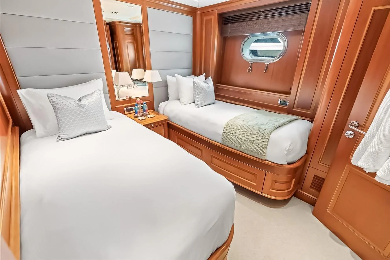 The guest stateroom features twin beds with plush bedding and warm wood accents. aboard GOTTA GO Yacht for Sale