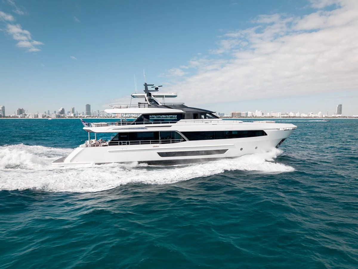A sleek and modern yacht cruises through the open water with a cityscape in the background. aboard OCEAN ALEXANDER 35P05 Yacht for Sale
