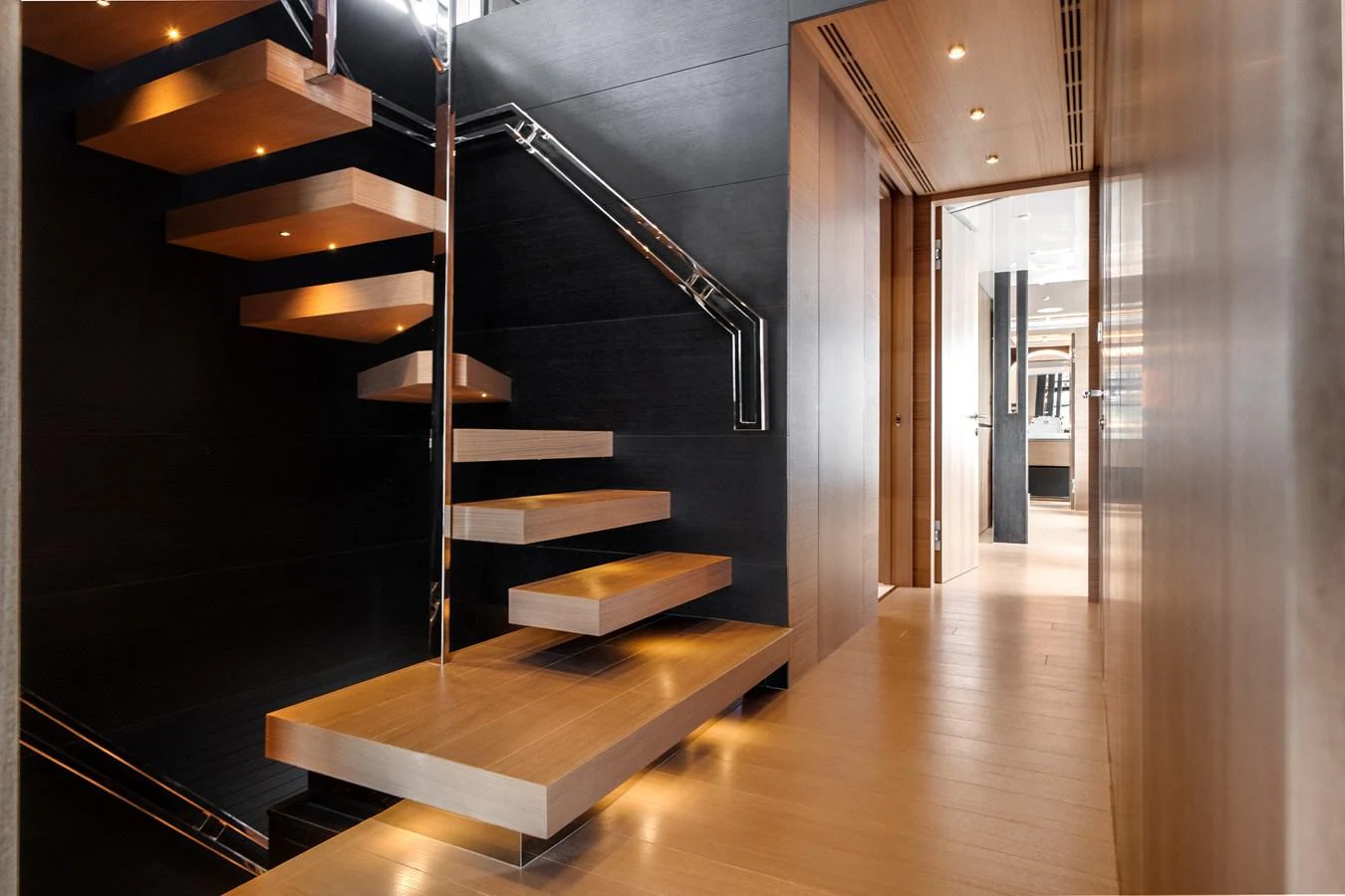 A modern staircase with floating wooden steps and sleek metal railings inside a luxurious yacht. aboard OCEAN ALEXANDER 35P05 Yacht for Sale