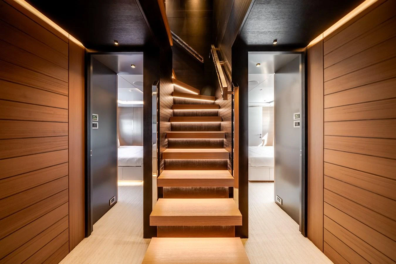 A luxurious staircase with warm wooden finishes and modern lighting leads to the upper deck. aboard OCEAN ALEXANDER 35P05 Yacht for Sale